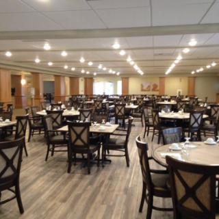 Empty dining hall with neatly arranged tables and chairs.