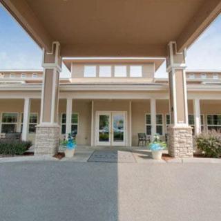 Front entrance of a building with columns and landscaping.