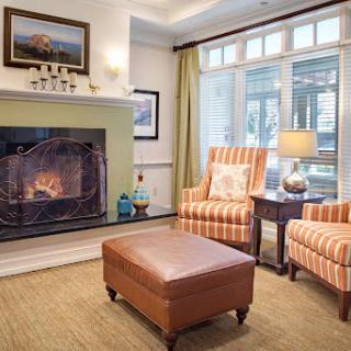 A cozy living room featuring a stylish fireplace, comfortable seating, and warm decor.