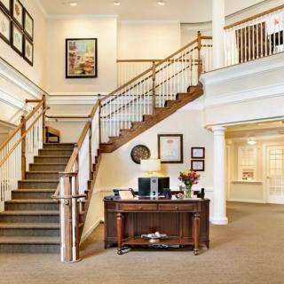 A spacious lobby with a central staircase and welcoming desk.