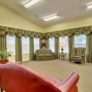 Traditional living room with elegant furnishings and large windows.