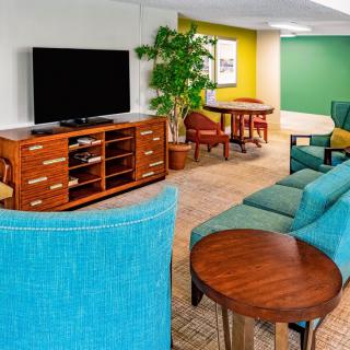 A modern living room with colorful furniture and a large television.