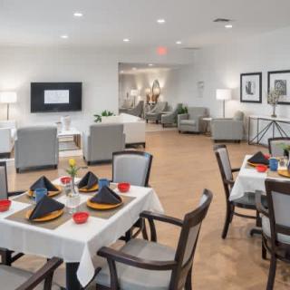 A modern dining area with elegantly set tables and a comfortable lounge space in the background.