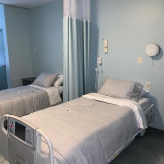 A view of a patient room in a hospital with two beds.