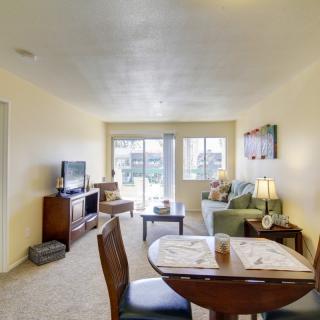 A cozy living room interior with a dining table, sofa, and television.
