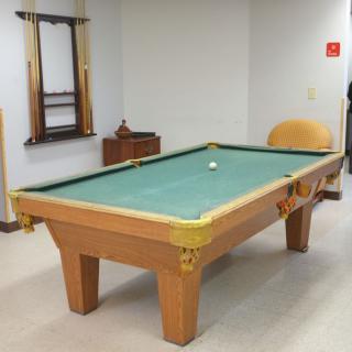 A billiard table in a game room setting.