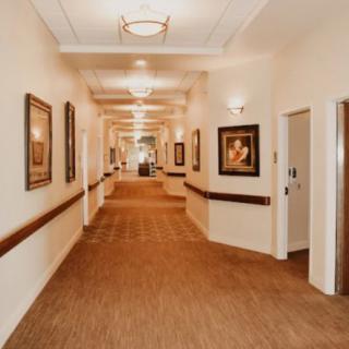 A well-lit hallway adorned with paintings on the walls.
