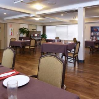 An empty restaurant dining area with tables and chairs arranged neatly.