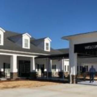A modern building with an entrance sign under a clear blue sky.