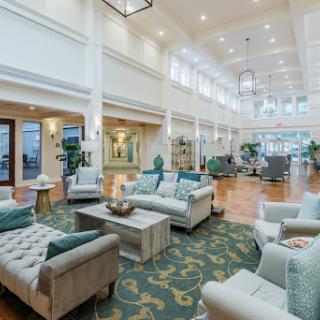 A bright and spacious lobby designed with modern furnishings and lush greenery, creating a welcoming atmosphere.