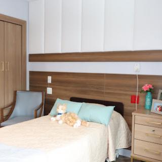 A cozy modern bedroom featuring a comfortable bed with light blue pillows, a stylish chair, and wooden accents.