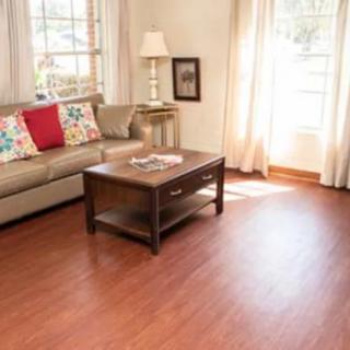 A cozy living room with a sofa, coffee table, and hardwood flooring.