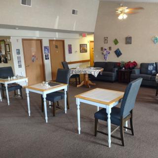 A cozy dining and lounge area with tables, chairs, and wall decorations.