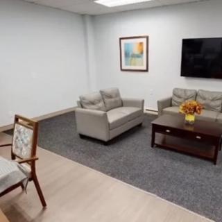 A cozy living room with a modern sofa set, coffee table, flat-screen TV, and wall art.