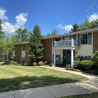 A suburban house with a well-maintained yard and clear blue sky.