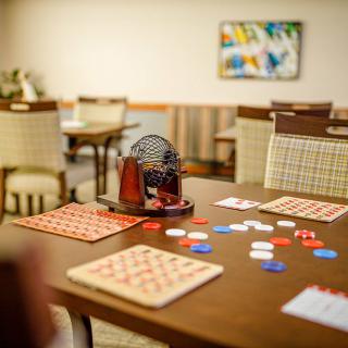 A cozy game room set up with bingo cards, chips, and a bingo machine on a table.