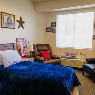 A cozy bedroom with comfortable seating and decorative elements.