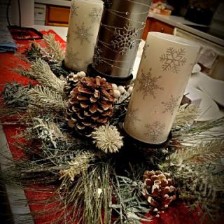 A beautiful holiday centerpiece featuring elegant candles and natural pinecone accents.