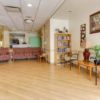 A cozy and inviting waiting area featuring comfortable seating and a bookshelf.