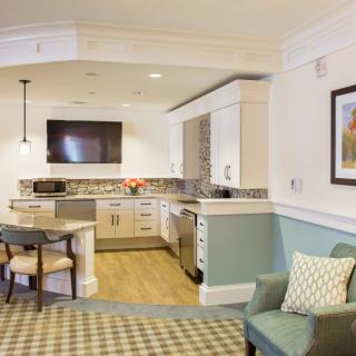 A cozy and modern kitchen with an adjacent living area, featuring stylish furniture and appliances.