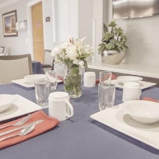 A beautifully arranged dining table with a floral centerpiece, ready for a meal.