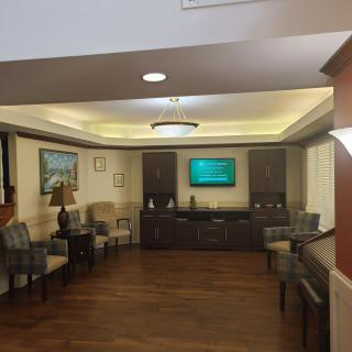 A modern waiting room with comfortable seating and a television.