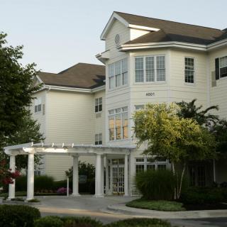 A multi-story residential building with a welcoming front entrance and landscaped surroundings.