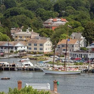 A picturesque coastal town with a harbor full of boats and charming waterfront buildings.