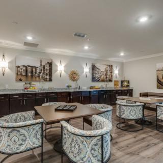A modern dining area featuring stylish chairs, contemporary artwork, and elegant lighting.