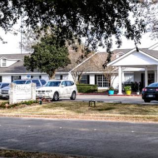 A view of a residential property with multiple vehicles parked outside.