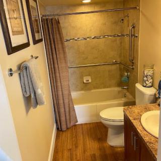 A neatly arranged bathroom with a shower-tub combination and contemporary decor.