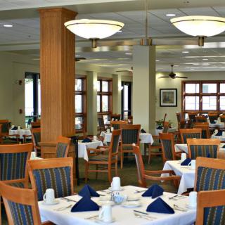 Elegant dining room setup with neatly arranged tables and chairs.