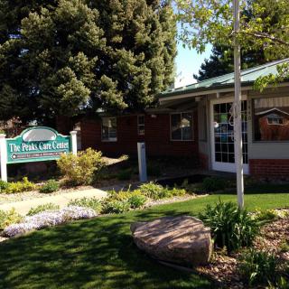 A view of a clinic building surrounded by well-maintained landscaping and greenery.
