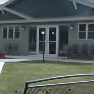 A suburban house with a well-maintained lawn and large windows.
