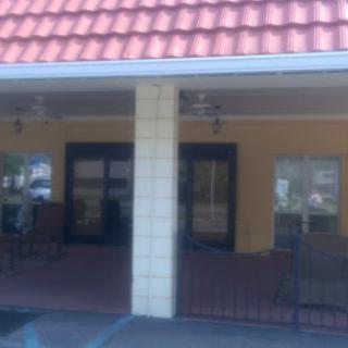 A view of a residential building's porch with a tiled roof.