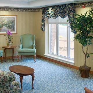 A cozy living room with elegant furniture and a large window bringing in natural light.