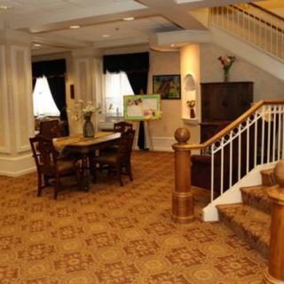 A cozy interior space featuring a traditional dining area and a wooden staircase.