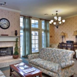 A cozy living room with a sofa, fireplace, and chandelier.