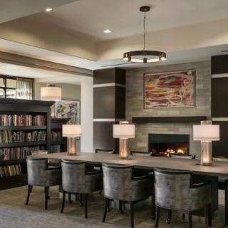 Modern library interior with a fireplace and reading area.