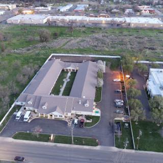 Aerial view of a residential complex with a parking lot, surrounded by greenery.