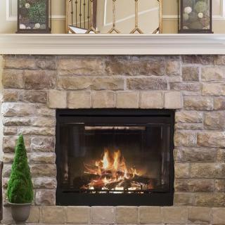A cozy stone fireplace with a warm fire burning inside, adding charm to the home's interior.