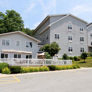 A view of a multi-story residential building surrounded by greenery.