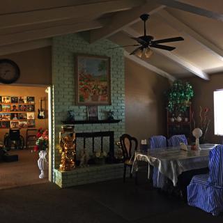 A cozy living and dining area featuring a fireplace, decorated table, and various decorations.