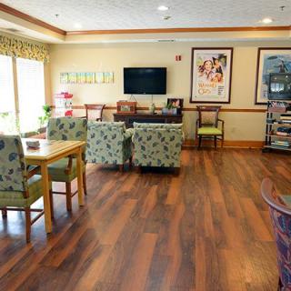 A cozy living room with comfortable seating, a television, and decorative artwork on the walls.