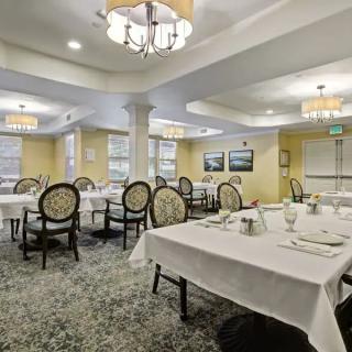 A spacious and elegantly decorated dining room with neatly arranged tables and chairs.