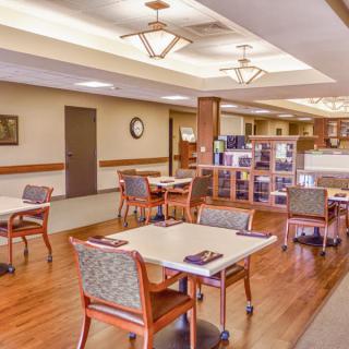 A spacious and well-lit dining area with neatly arranged tables and chairs.