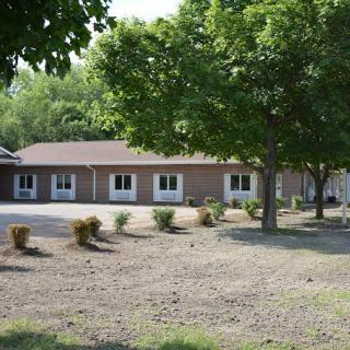 A suburban building surrounded by trees and greenery.