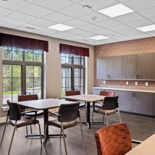 A modern dining area with tables, chairs, and ample natural light.