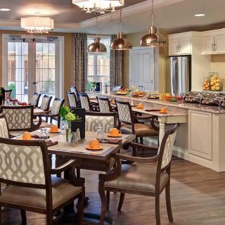 A modern dining room with elegant furnishings and a connected kitchen area.