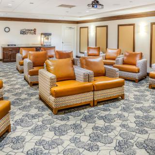 A comfortable lounge area with multiple armchairs arranged on a patterned carpet.